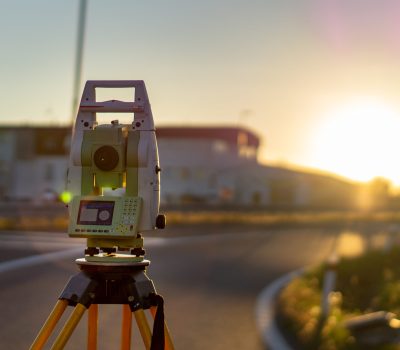 Surveyor equipment (theodolit or total positioning station) on the construction site of the motorway or road during sunrise