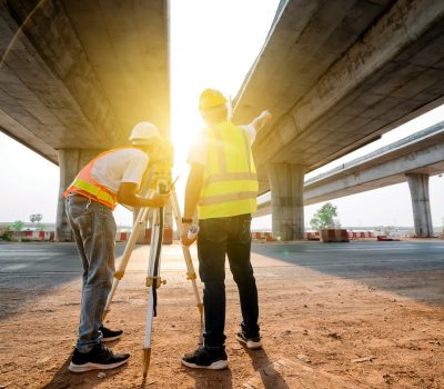 Asian civil engineer team working with theodolite and highway construction drawing paper Civil workers surveying at the road construction site